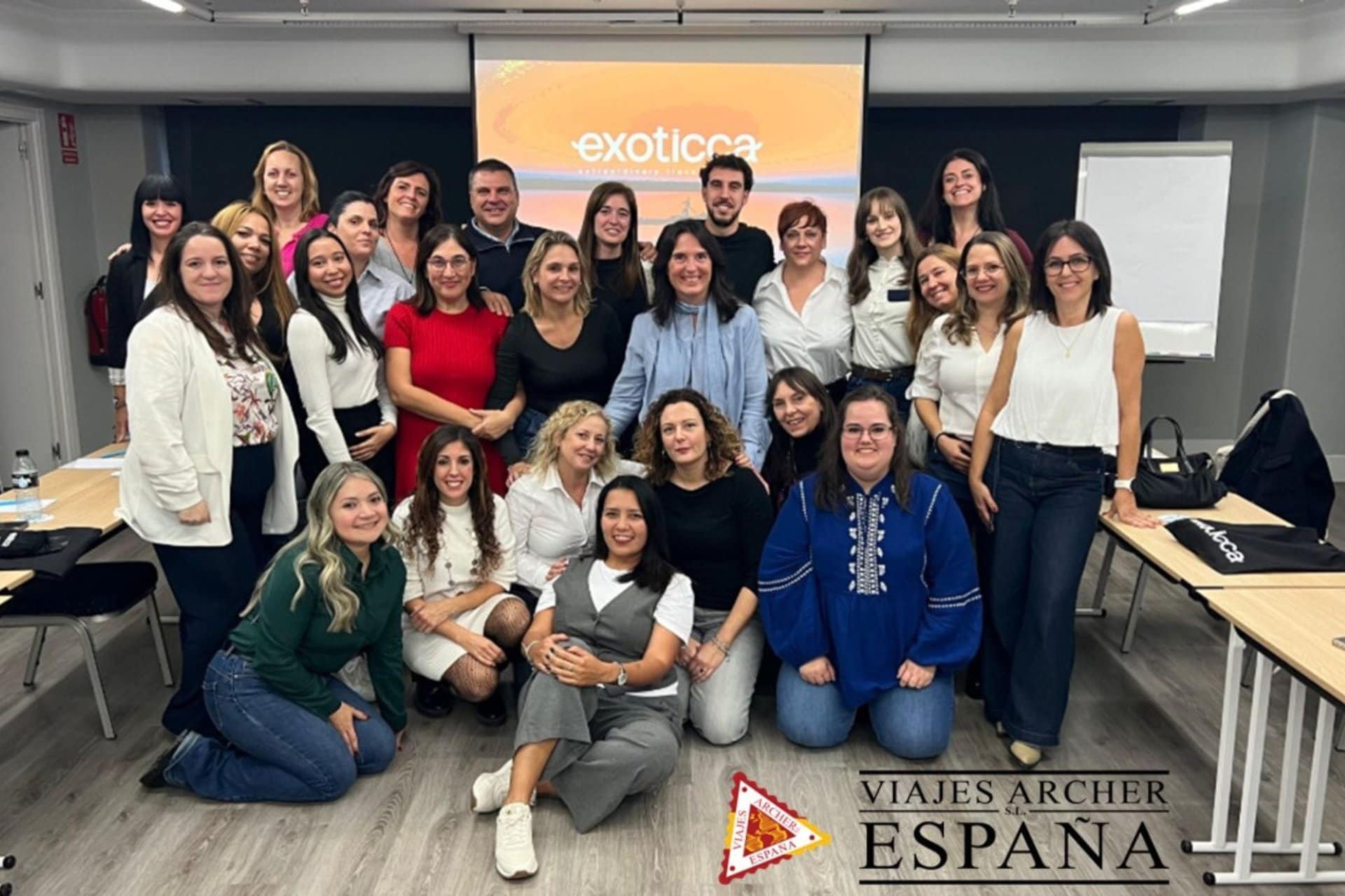 Viajeros en una sala de conferencias con pantalla y proyector, participando en un evento de viajes o.