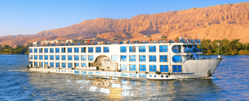 Barco en el río Nilo con montañas al fondo, durante un viaje en Egipto.