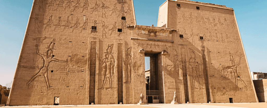 Torre antigua con relieves egipcios en un sitio arqueológico en Egipto.